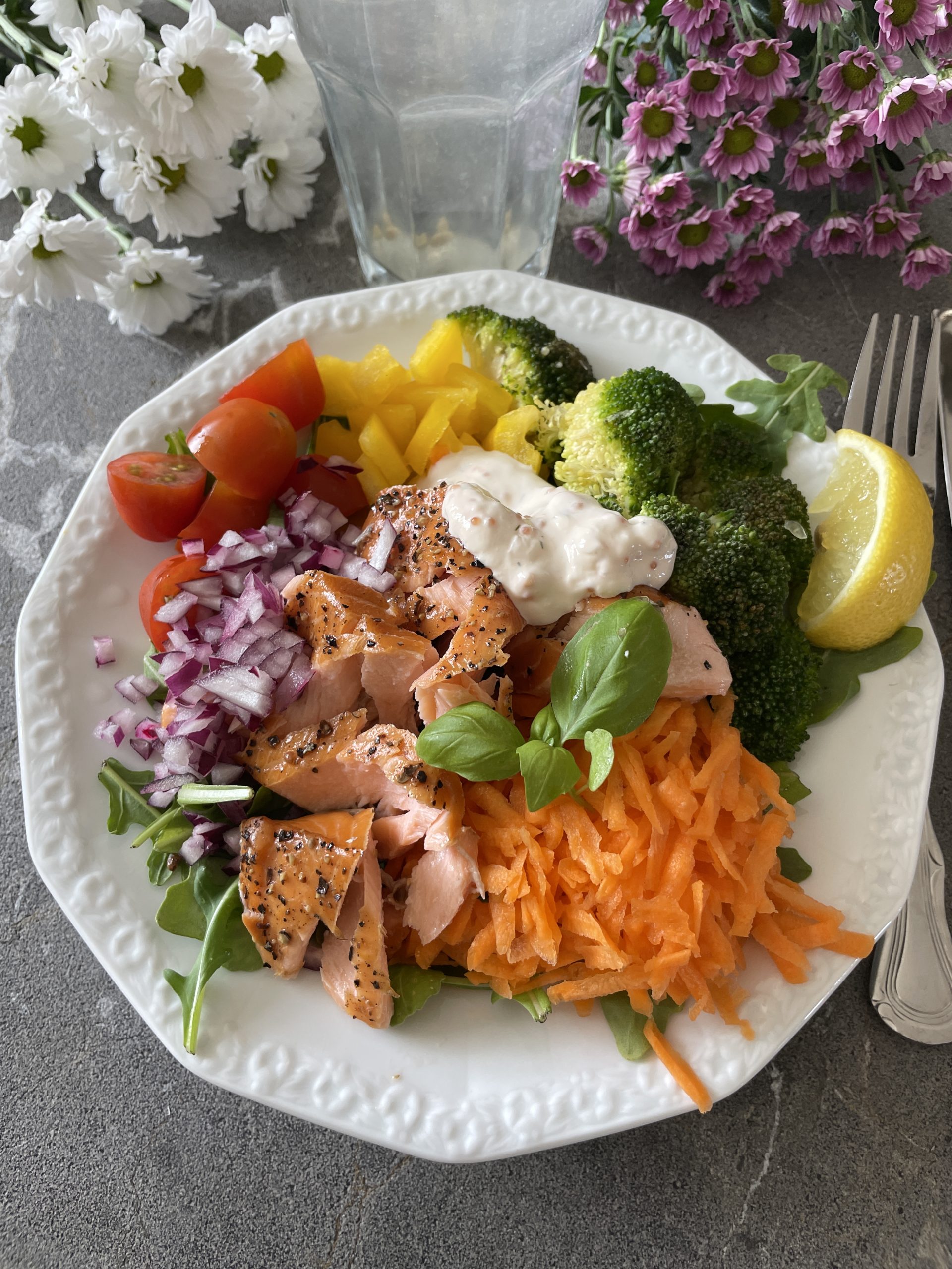 Varmrökt lax med råkostsallad av färska grönsaker på vit tallrik – hälsosam måltid rik på protein, vitaminer och omega-3.