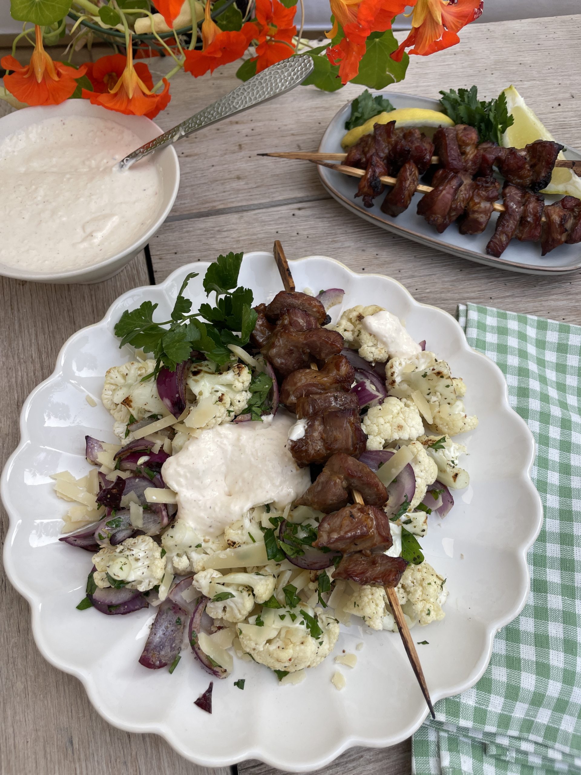 Grillspett med saftiga bitar av fläskkarré, fint grillade med lätt karamelliserad yta. Serveras tillsammans med blomkål, antingen rostade buketter eller som ett ljust tillbehör vid sidan på tallriken.
