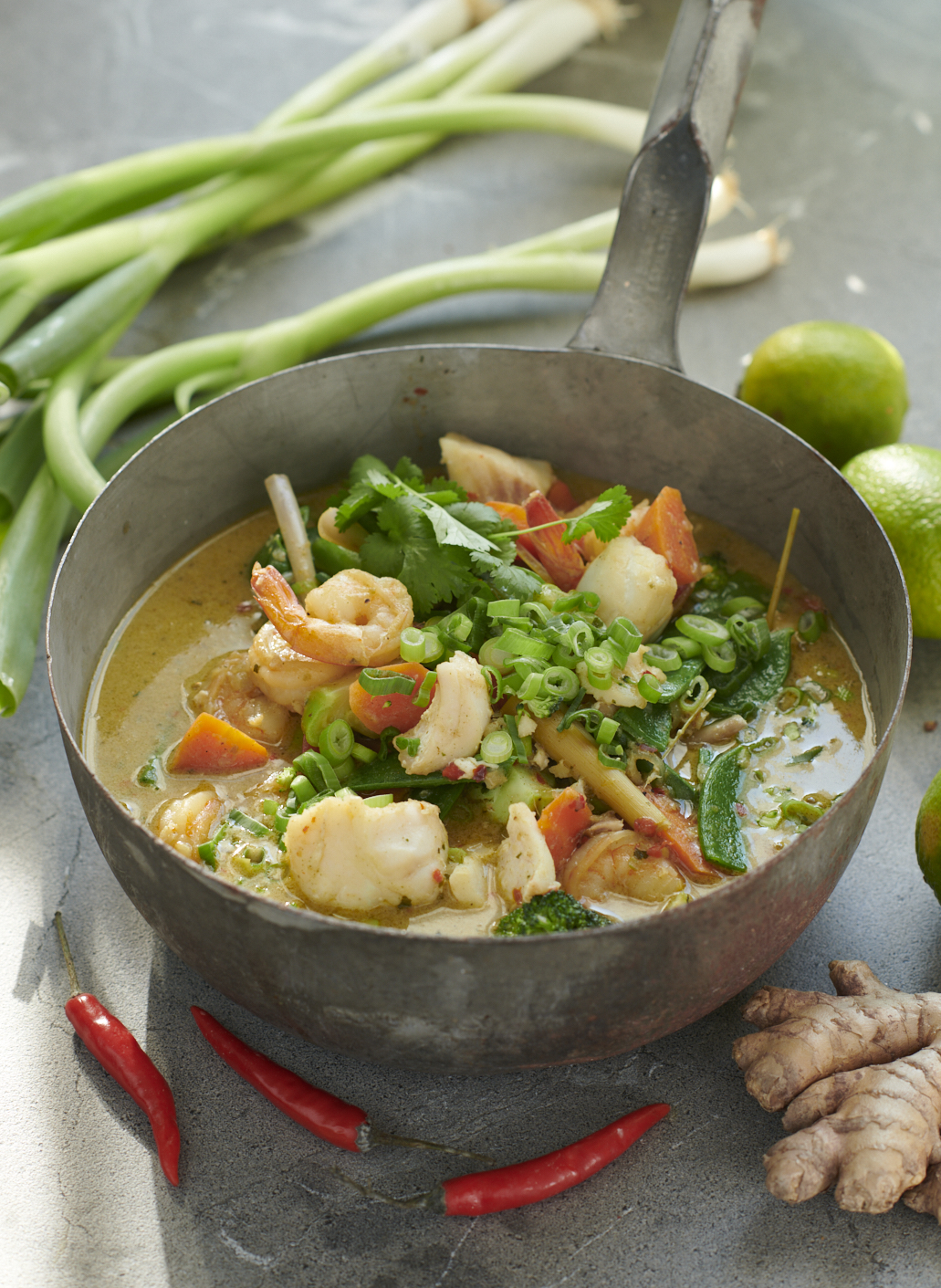 Asiatisk gryta med torsk och räkor, serverad i skål på grå stenskiva