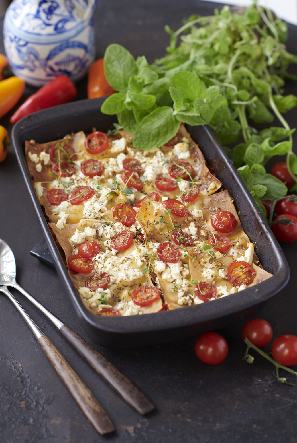 Nyttig lasagne med köttfärs, ost och tomatsås i ugnsform, serverad på grå stenskiva